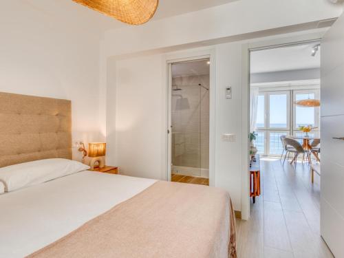 a bedroom with a bed and a dining room at Hanami Avenida de España Oceanfront in Estepona