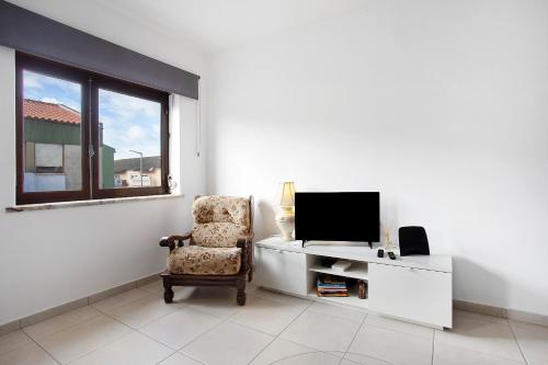 a living room with a chair and a television at A O - Augusta in Peniche