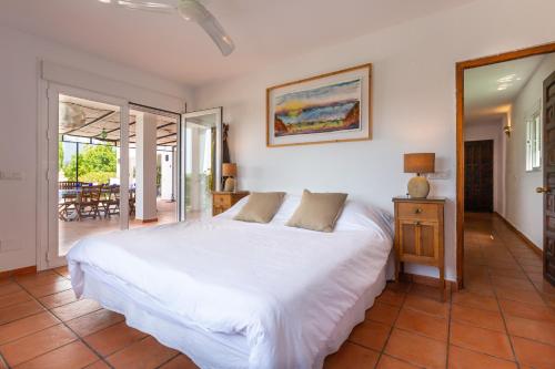 a bedroom with a large white bed and a patio at Almijan Alegria in Estepona