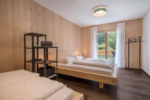 a bedroom with two beds and a window at Naturapartments Alpreid Tanne in San Pancrazio dʼUltimo