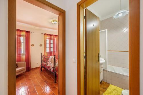 a bathroom with a tub and a toilet and a sink at Burgau - A Casa dos Avós in Burgau