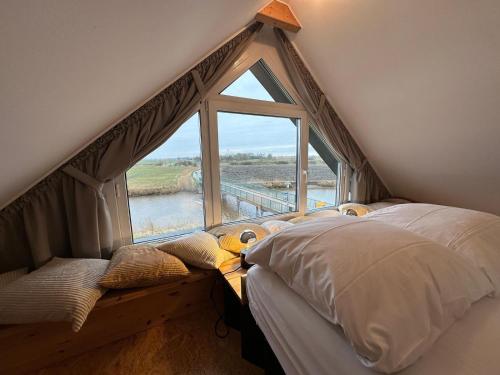 a bedroom with a large window and a bed in a room at Großzügiges modernes Ferienhaus in Neuharlingersiel