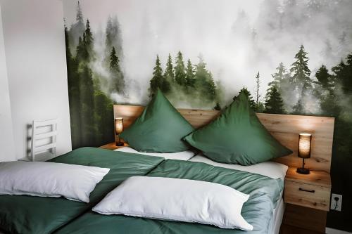 a bedroom with two green beds with a forest mural on the wall at Fewo Waldfeeling in Brilon