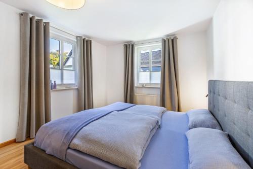 a bedroom with a bed and two windows at Fewo Allezeit Sauerland in Drolshagen