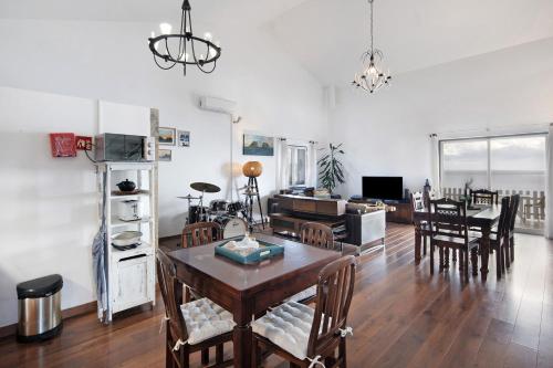 a dining room and living room with a table and chairs at Breathe Nature - Beach House Azores in Feteira