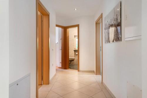 a hallway with white walls and a doorway to a bathroom at Apartment Bodnerhof in Nova Ponente