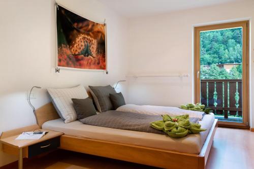 a bedroom with a bed with a table and a window at Apartment Bodnerhof in Nova Ponente