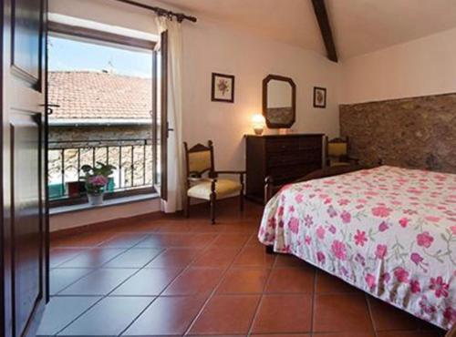 a bedroom with a bed and a mirror and a window at Agriturismo Il Colletto in Albenga