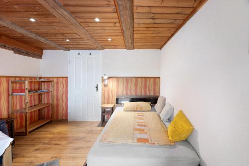a bedroom with a bed and a wooden ceiling at Bachbubenhof in Hüfingen