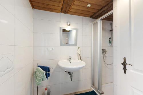 a white bathroom with a sink and a shower at Bachbubenhof in Hüfingen