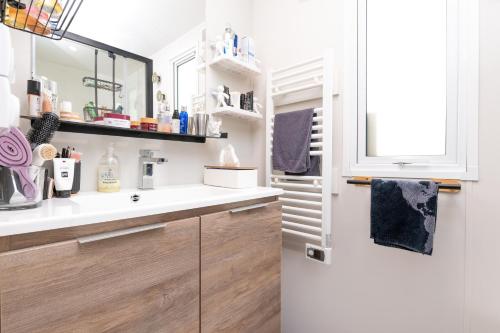 a bathroom with a sink and a mirror at Mobilhome - Piscine - Premium in Erdeven