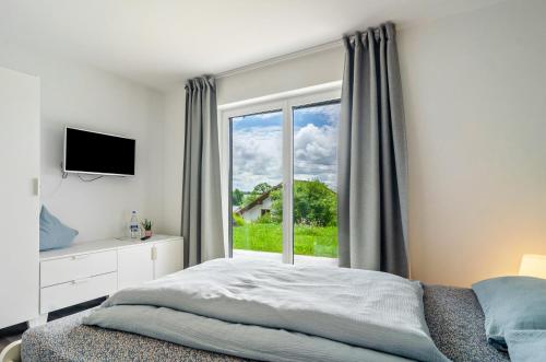 a bedroom with a bed and a large window at Kleine Auszeit in Thalheim