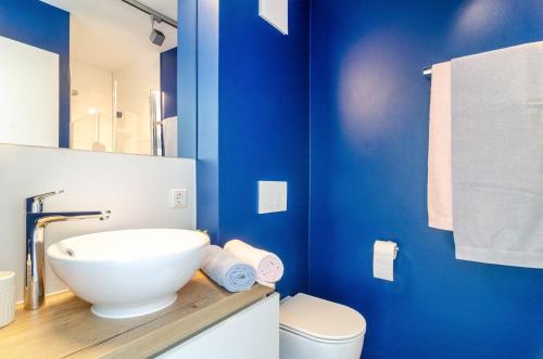 a bathroom with a white sink and a blue wall at Kleine Auszeit in Thalheim
