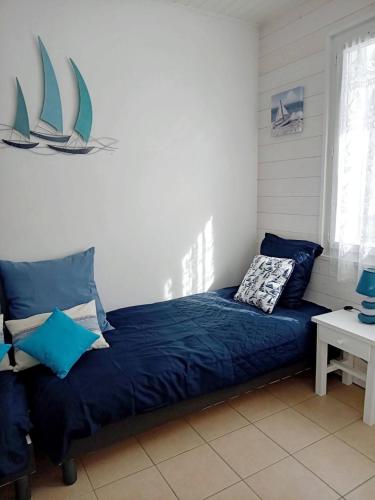 a bedroom with a bed with blue sheets and sails on the wall at Maison du centre - ruelle calme in La Tranche-sur-Mer