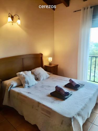 a bedroom with a bed with two hats on it at Los Cerezos in Rada