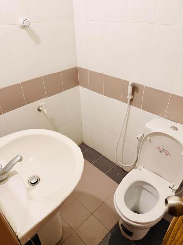 a bathroom with a toilet and a sink at C&C Holiday Home in Nikawatawana