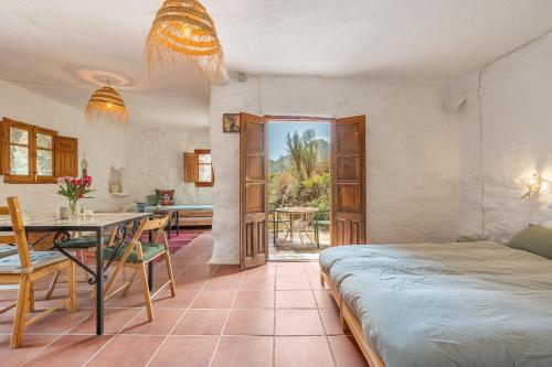a bedroom with a bed and a table and a dining room at Off-Grid - Puerto Mika in Órgiva