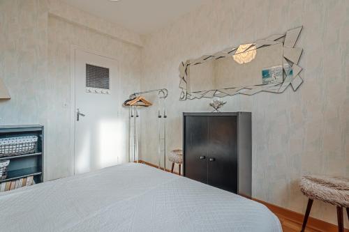 a bedroom with a bed and a mirror on the wall at Appartement Le Rial - Erquy in Erquy