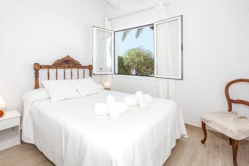 a bedroom with a white bed and a window at Villa Kassiopea in Cala Blanca