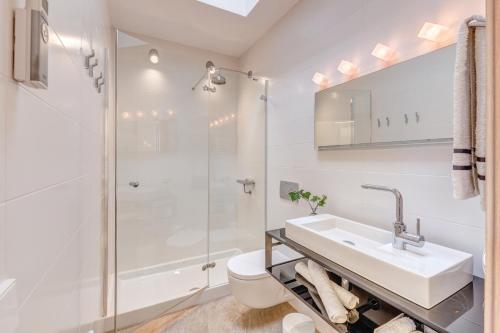 a white bathroom with a sink and a shower at Es Pop Nou in Sa Ràpita