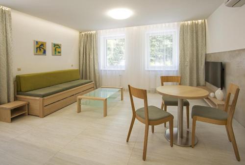 a living room with a couch and a table at HOTEL A RESTAURACE U STAVAŘE in Vsetín