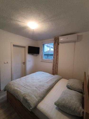 a bedroom with a large bed and a window at Guesthouse Flaghome in Mostar