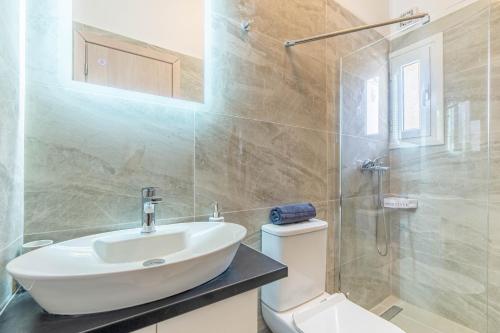 ein Badezimmer mit Waschbecken, Toilette und Dusche in der Unterkunft Rozario in Alepou