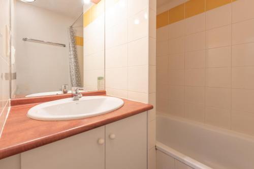 a bathroom with a sink and a bath tub at T2 avec piscine couverte et parking in Saint-Lary-Soulan