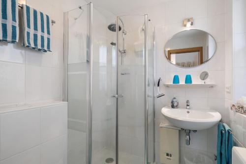 a white bathroom with a shower and a sink at Ferienhaus Gerster in Mitten