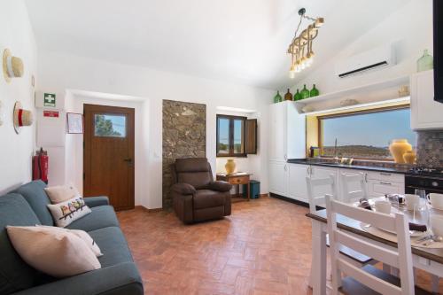 a living room with a couch and a table and a kitchen at Casas do Monte I in Giões