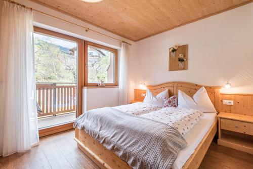 a bedroom with a bed and a large window at Huberhof App Rubens in Feldthurns