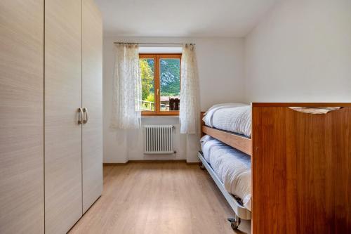 a small bedroom with a bed and a window at Casa Valentina in Ledro