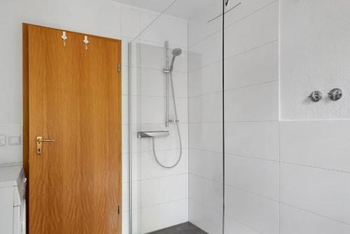 a bathroom with a shower with a wooden door at Haus Reiser in Alpirsbach