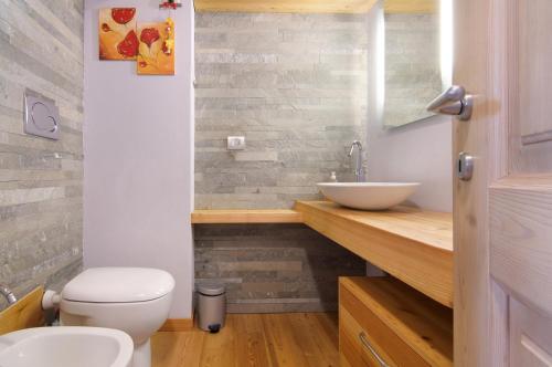 a bathroom with a white toilet and a sink at Casa Pollicina in Margno