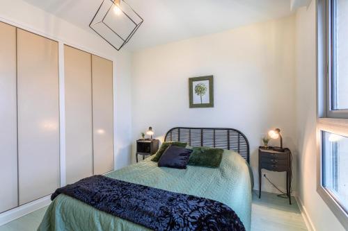 a bedroom with a bed and a window at La Houle, appartement face mer in Les Sables-d'Olonne