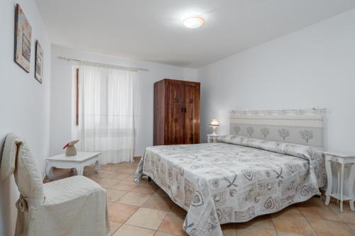 a bedroom with a bed and a chair at Casa Bice 2 in Golfo Aranci