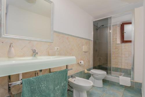a bathroom with a sink and a toilet and a mirror at Casa Bice 2 in Golfo Aranci