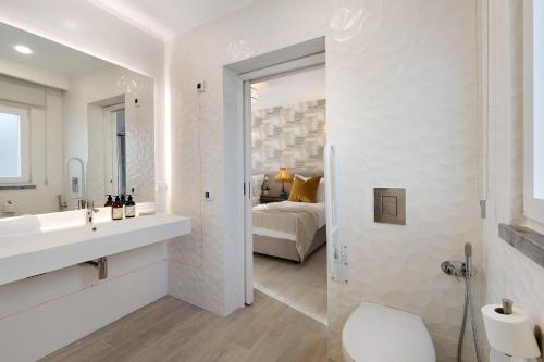 a white bathroom with a sink and a bedroom at Casa Mourato - Smart and Eco Wonder in São Domingos de Rana
