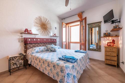 a bedroom with a bed and a mirror and a television at Adriana's house in Buggerru
