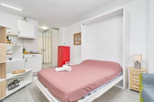a bedroom with a red bed and a red refrigerator at Estudio El Faro 2 in Torrox