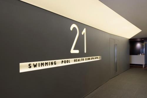 a sign that reads swimming pool health qualification on a wall at The Act Hotel Sharjah in Sharjah
