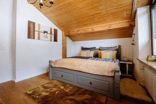 a bedroom with a bed with a wooden ceiling at Ferienwohnung Seeidyll am Wörthsee in Wörthsee