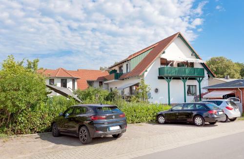 two cars parked in a parking lot in front of a house at Gästehaus Knuth Zinnowitz in Zinnowitz