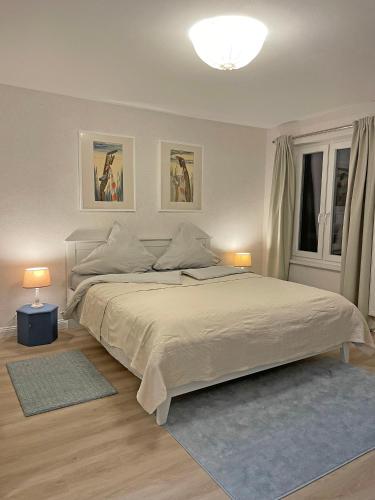 a bedroom with a large white bed with two lamps at Ferienwohnung Ankerleicht in Steinbergkirche