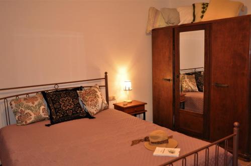 a bedroom with a bed with a hat and a mirror at House For Rent In Apostolous in Apóstoloi