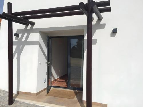 a modern house with a glass door and black beams at Amado Properties in Carrapateira