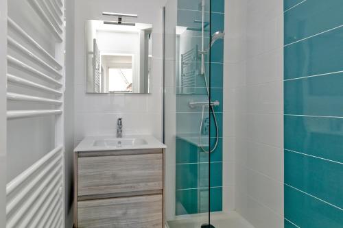 a bathroom with a sink and a glass shower at Maisons de Saint Guenolé in Batz-sur-Mer