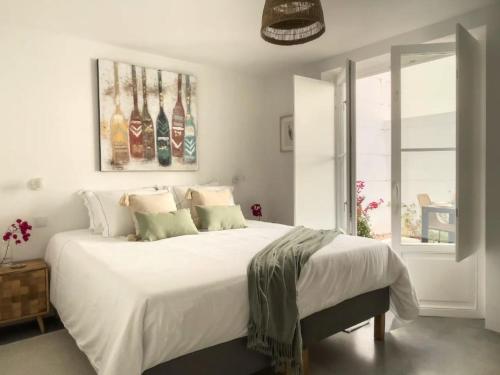 a bedroom with a large bed with white sheets and pillows at Jasmine House in Tavira