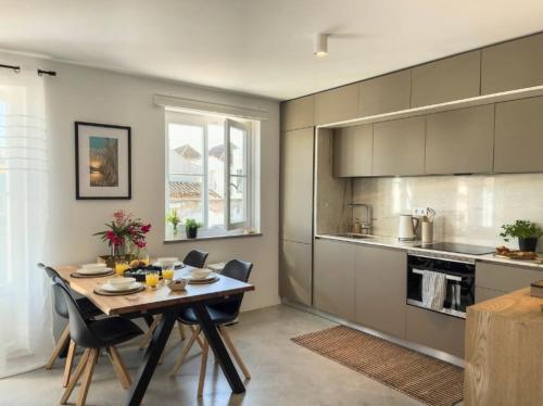 a kitchen and dining room with a table and chairs at Jasmine House in Tavira