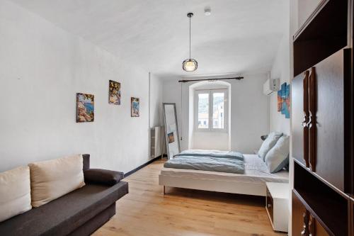 a bedroom with a bed and a couch at Casa Leah in Imperia